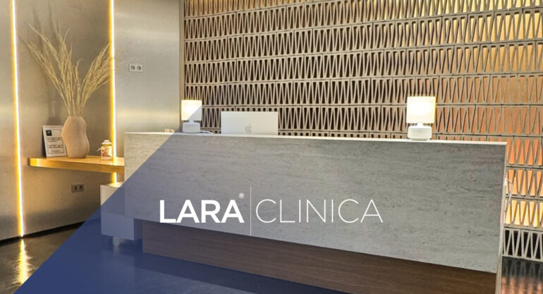 Mostrador de recepción moderno y luminoso con el logotipo de Clínica Lara, destacando un diseño elegante con paredes texturizadas y luz cálida.